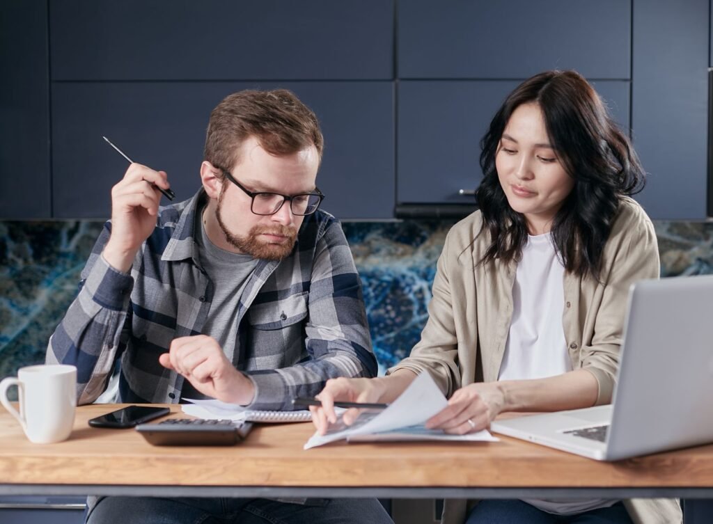 Samen een huishoudbudget bespreken met een rekenmachine — sfeerbeeld